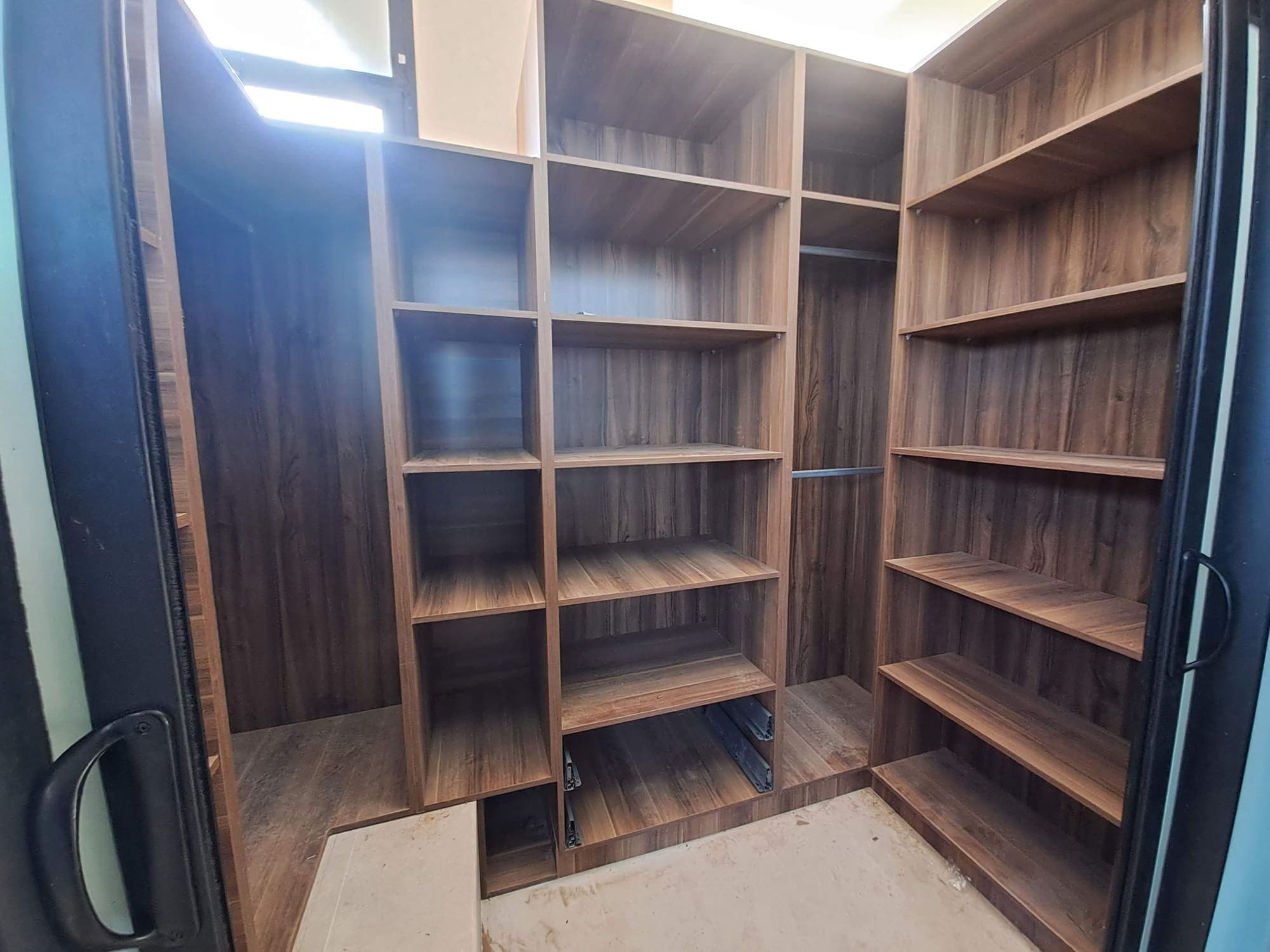 Dressing en bois foncé avec étagères ouvertes et penderie