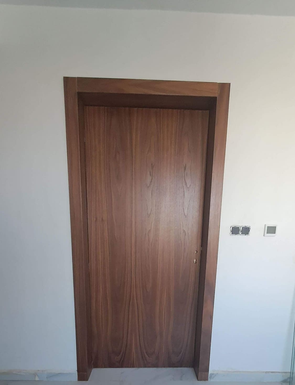 Porte intérieure en bois foncé à encadrement assorti